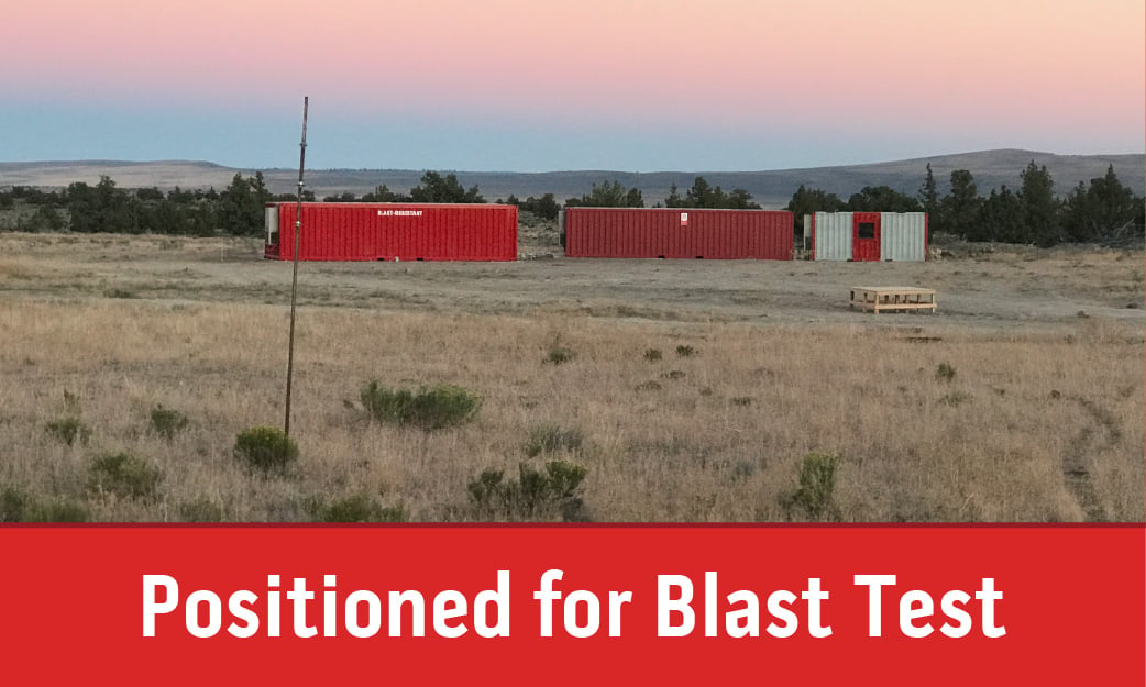 Blast-resistant buildings positioned on a test range before a controlled blast test.