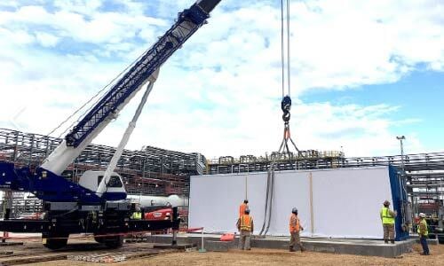 Blast-resistant building being installed onsite with crane during turnaround preparation